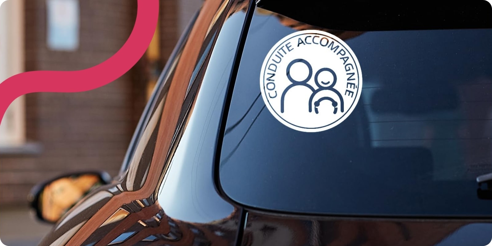 vitre arrière d'une voiture dotée d'un macaron de conduite accompagnée